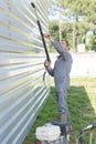 Professional worker powerwashing outside building powered by generator