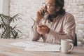 Professional worker speaking at the phone sitting at the desk. Business man talking on cellular smartphone. Paper notes and job. Royalty Free Stock Photo