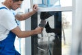 Professional worker tinting window with foil indoors