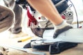 professional worker using a mitre-saw and angle grinder for cutting metal and aluminium