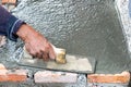 Professional worker using trowel for building cement floor. Royalty Free Stock Photo