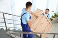 Professional workers carrying wooden rack on stairs. Moving service