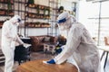 Professional workers in hazmat suits disinfecting indoor of cafe or restaurant, pandemic health risk, coronavirus