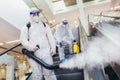 Workers in hazmat suits disinfecting indoor of mall, pandemic health risk, coronavirus Royalty Free Stock Photo