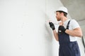 Professional Workman Applying Silicone Sealant With Caulking Gun on the Wall