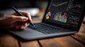 Stylus Interacting with Business Analytics on Laptop Screen with Gradient Glass Glow and Data Visualization Ambiance Royalty Free Stock Photo