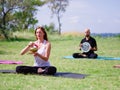 A group of four holds yoga classes in the park. Healthy lifestyle. Royalty Free Stock Photo