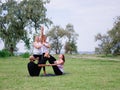 A group of four holds yoga classes in the park. Healthy lifestyle. Royalty Free Stock Photo