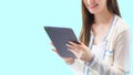 Professional young age Asian business woman with long hair in white shirt holds tablet her smiling happily isolated on blue Royalty Free Stock Photo