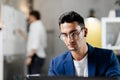 Professional young architect in glasses dressed in blue checkered jacket works on the laptop in the office Royalty Free Stock Photo