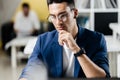 Professional young architect in glasses dressed in blue checkered jacket works on the laptop in the office Royalty Free Stock Photo