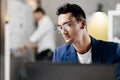 Professional young architect in glasses dressed in blue checkered jacket works on the laptop in the office Royalty Free Stock Photo