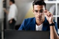 Professional young architect in glasses dressed in blue checkered jacket works on the laptop in the office Royalty Free Stock Photo