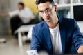 Professional young architect in glasses dressed in blue checkered jacket works on the laptop in the office Royalty Free Stock Photo