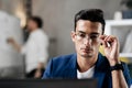 Professional young architect in glasses dressed in blue checkered jacket works on the laptop in the office Royalty Free Stock Photo