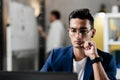 Professional young architect in glasses dressed in blue checkered jacket works on the laptop in the office Royalty Free Stock Photo