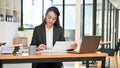 Professional Asian female accountant focusing on her sales accounts, using calculator Royalty Free Stock Photo