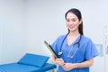 Professional young Asian woman doctor standing smiling in medical uniform blue lab shirt Royalty Free Stock Photo