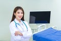 Professional young Asian woman doctor wearing white robe standing with arms crossed. Wearing a white robe and stethoscope happy Royalty Free Stock Photo