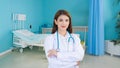 Professional young Asian woman doctor wearing white robe and stethoscope standing with arms crossed happy and smile Royalty Free Stock Photo