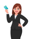 Professional young business woman showing or holding credit/debit/ATM card. Female executive displaying banking card. Modern.