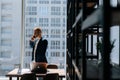 Professional young businessman wearing fashion suit is talking on mobile phone in modern office room Royalty Free Stock Photo