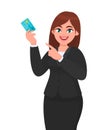 Professional young businesswoman showing/holding credit/debit/ATM banking card and pointing hand finger towards, presenting.