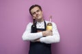 Professional young handsome waiter in uniform hugs two bottles of red and white wine on a pink background, concept love of alcohol Royalty Free Stock Photo