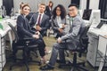 Professional young multiethnic business team sitting together and smiling at camera Royalty Free Stock Photo