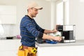 professional young worker fixing coffee machine Royalty Free Stock Photo