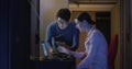 IT professionals collaborating on tablet and laptop in server room, focused on task Royalty Free Stock Photo