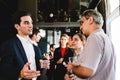Professionals networking at a corporate event, engaged in conversation and holding drinks in a modern venue Royalty Free Stock Photo