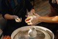 Professions Ideas. Woman potter teaching the art of pot making. Child working on potters wheel making clay objects in pottery Royalty Free Stock Photo