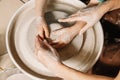 Professions Ideas. Woman potter teaching the art of pot making. Child working on potters wheel making clay objects in pottery Royalty Free Stock Photo