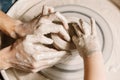 Professions Ideas. Woman potter teaching the art of pot making. Child working on potters wheel making clay objects in pottery Royalty Free Stock Photo