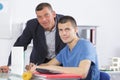 Professor assisting student with studies in college library Royalty Free Stock Photo