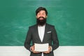 Professor in class on blackboard background. Tutoring. Young bearded teacher near chalkboard in school classroom Royalty Free Stock Photo