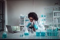 Professor working at the research center using a microscope. chemists working with blue liquids in tubes at The Chemical Research