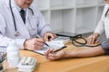 Professor doctor attentive patient being measuring and checking blood pressure to patient, hospital and medicine concept