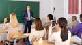 Professor explaining function graph to adult students in auditorium