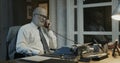 Professor sitting at desk and having a phone call Royalty Free Stock Photo