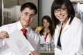 Professor With Student Holding Curriculum Paper In Lab Royalty Free Stock Photo