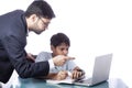 Father teaching son with the help of computer and books, pointing finger towards screen Royalty Free Stock Photo