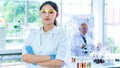 Professor woman researcher white gown stands confident with face concentration. With background interior white lab and the senior
