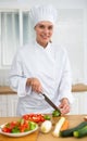 Proffesional woman cook in white uniform chopping vegetables Royalty Free Stock Photo