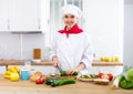 Proffesional woman cook in white uniform chopping vegetables