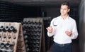 Proficient young man holding glass of wine in cellar Royalty Free Stock Photo