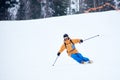 Proficient young skier concentrated on skiing down on steep ski slope. Extreme winter activities concept. Front view