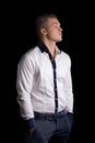 Profile of attractive young man with white shirt, hands in pockets