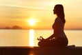 Profile of woman silhouette doing yoga exercise at sunset